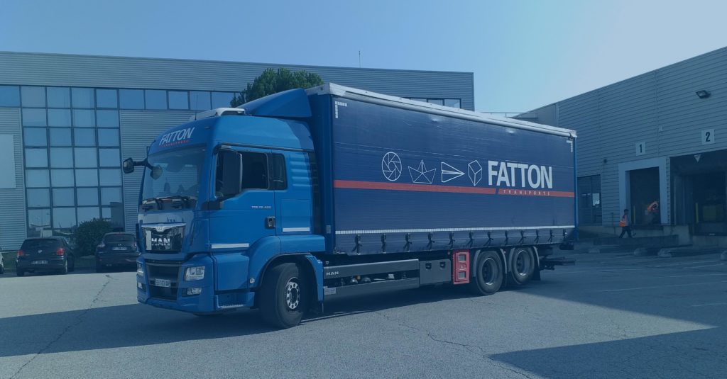 Camion FATTON Transports garé devant un entrepôt